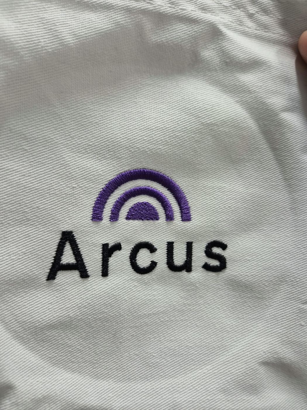Arcus logo embroidered on a white garment