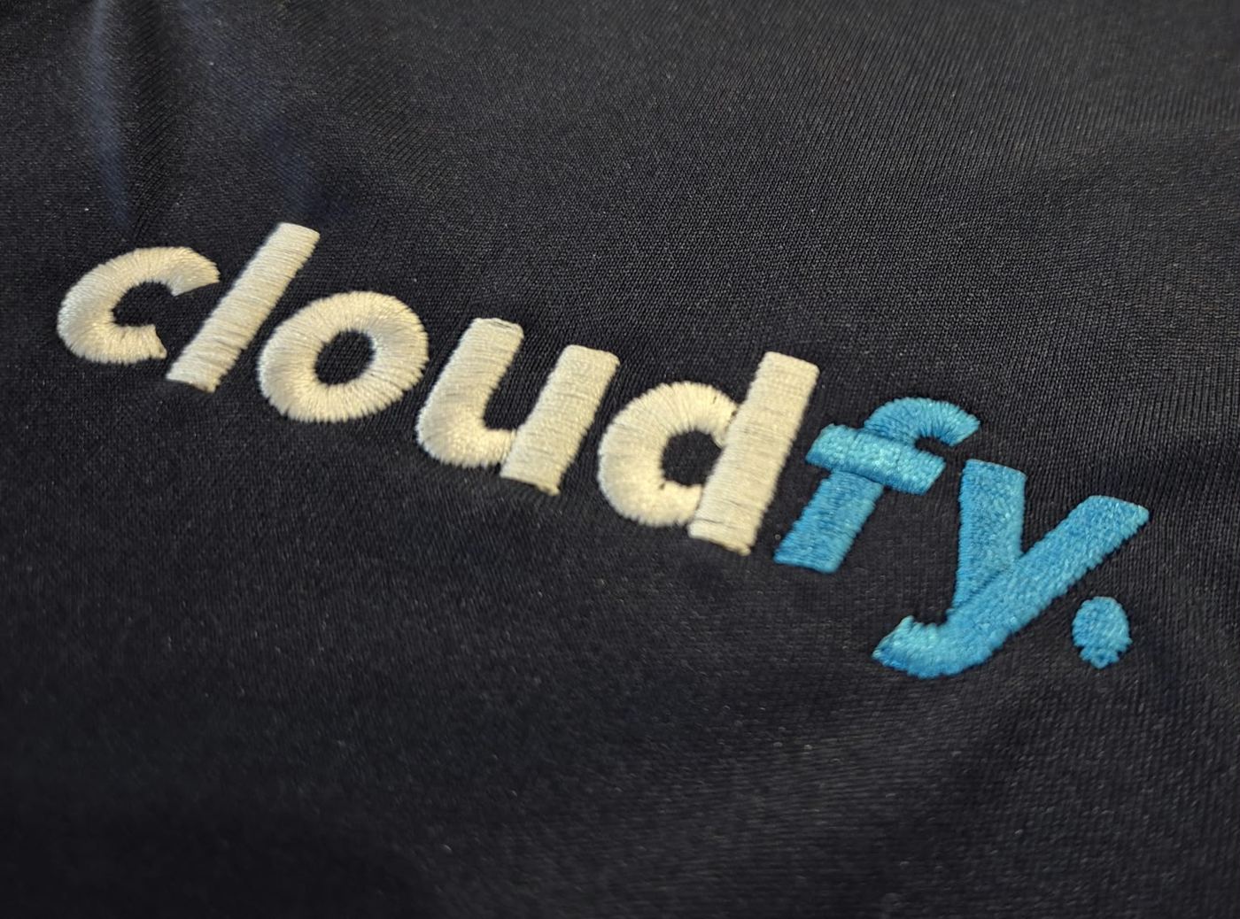 Cloudfy logo embroidered on a black garment