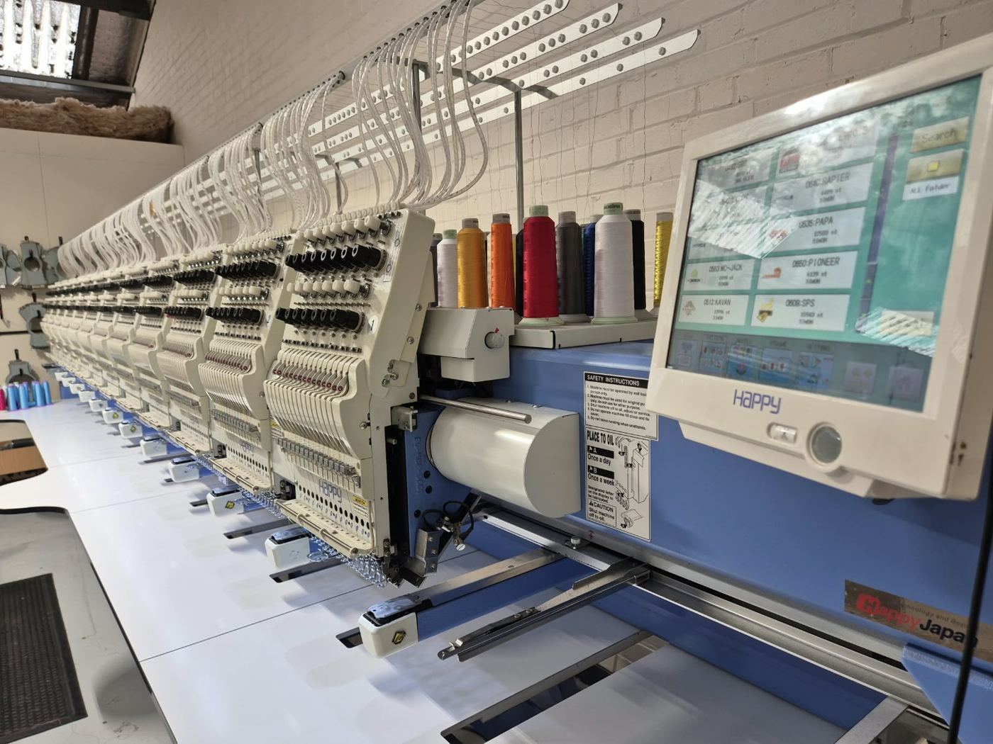 Line of multi head embroidery machines in our Leicester studio