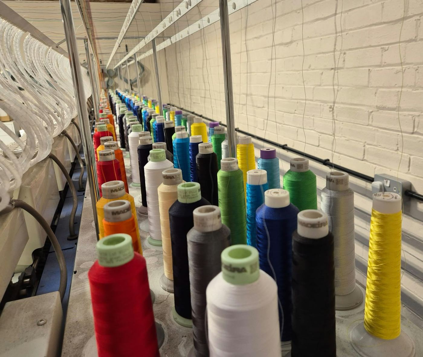 Rows of embroidery thread cones loaded on the machines